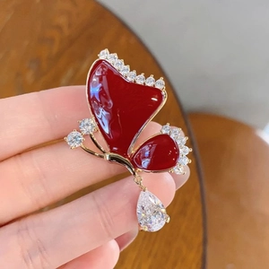 Elegant red enamel butterfly brooch with sparkling zircons and a pear-cut drop pendant