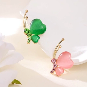 Détail de broches papillon avec pierres œil-de-chat vertes et roses et placage doré