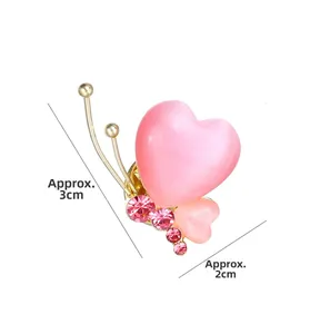 Détail de la broche papillon coeur œil de chat rose avec plaquage or et strass