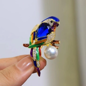 Elegant parrot brooch with colorful enamel details and white pearl on gold plating