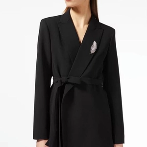 Elegant silver feather brooch with crystals on a black suit lapel for formal style