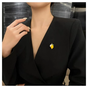 Broche citron jaune mignonne pour femme avec détail de feuille verte sur blazer noir