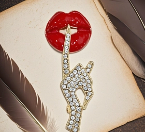 Macro shot of red enamel lips and crystal finger brooch with shimmering rhinestone details