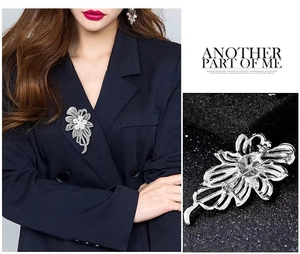 Détail de la broche fleur avec perles et zircons sur costume et vue de l'épingle arrière