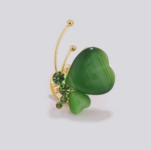 Broche papillon dorée avec ailes en œil-de-chat vert et cristaux étincelants