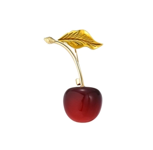 Detailed close-up of cherry brooch with deep red resin fruit and golden metal leaves