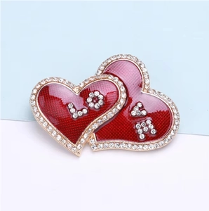 Macro shot of red heart brooch with crystal LOVE letters and gold alloy edges