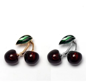 Close-up of sweet cherry brooches with red resin fruit and green enamel leaf detail