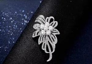 Gros plan détaillé d'une broche fleur argentée avec perles blanches et strass brillants
