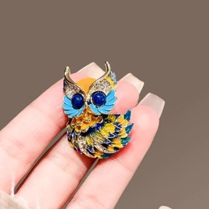 Broche chouette en émail aux couleurs bleu et jaune et yeux en pierres bleu marine