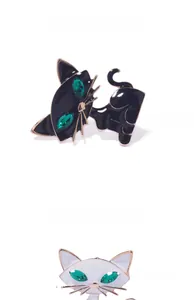 Dettaglio di graziose spille a gatto con occhi in zircone verde e placcatura in oro