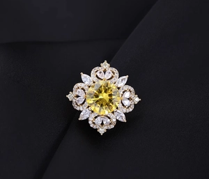Macro shot of luxury emerald crystal brooch with gold metal frame on black silk background