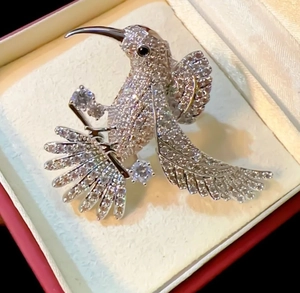 Macro detail of bird brooch with sparkling inlaid gems and elegant wing design