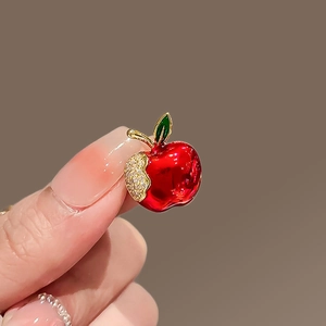 Macro shot of red apple brooch with sparkling rhinestones and vivid enamel finish