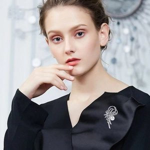 Eleganter Narzissenblüten-Brosche mit Perle und Strass auf schwarzer Kleidung