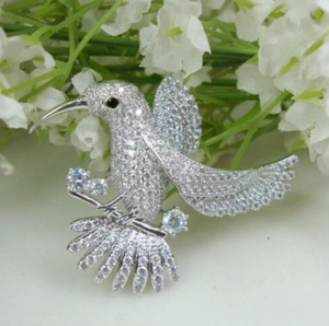 Elegant hummingbird brooch in silver finish with pavé crystals and sparkling gemstones