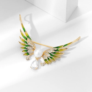 Détail macro de la broche ailes d'ange en émail avec perle et cristal goutte d'eau