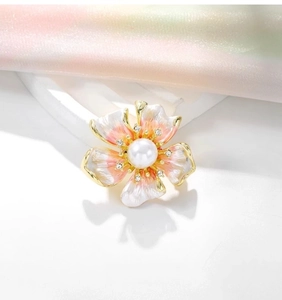 Dettaglio della spilla a forma di peonia in smalto rosa con perla centrale e strass