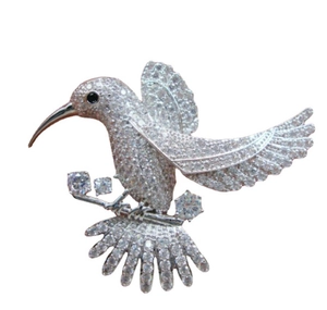 Detailed macro view of hummingbird brooch with white crystals and geometric gems