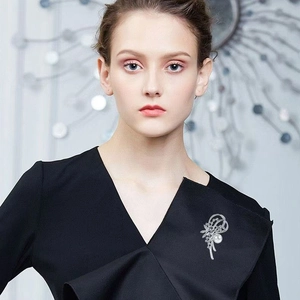 Elegante silberne Narzissenbrosche mit weißer Perle und Kristallen an schwarzem Kleid