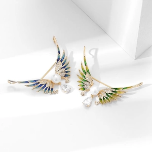 Détail de broches ailes d'ange en émail dégradé avec perles et pendentifs en zircon
