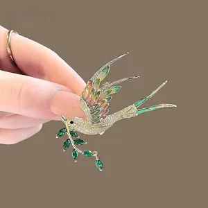 Détail de la broche pie avec ailes en émail dégradé et cristaux étincelants