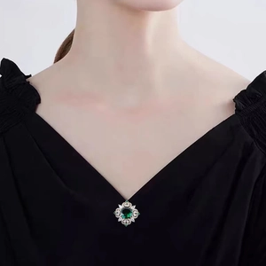 Elegant emerald crystal floral brooch with green gemstone and white rhinestones