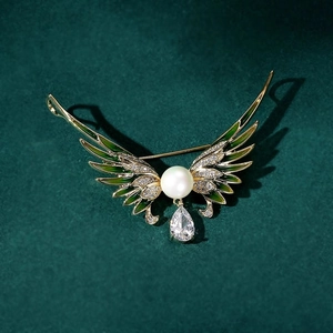 Détails de la broche ailes d'ange avec émail vert, perle blanche et zircon goutte