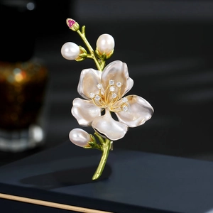 Dettaglio della spilla a magnolia con perle, petali in smalto rosa e accenti di foglie verdi