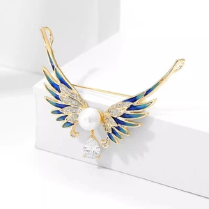 Détail de broche ailes d'ange en émail bleu avec perles et pendentif zircon goutte