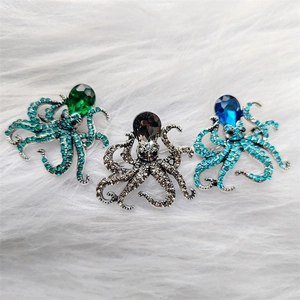 Detailed view of octopus brooches with emerald, sapphire blue, and grey rhinestones