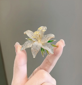 Detailed close-up of luxury lily flower brooch with silver petals and sparkling crystals