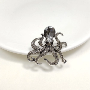 Close-up of vintage octopus brooch with grey rhinestones and pear-cut crystal inlay