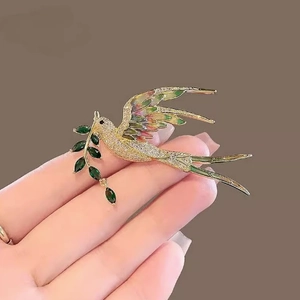 Broche pie exquise en or avec des ailes colorées et des feuilles de gemmes vertes