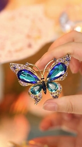 Detail of vintage butterfly brooch with deep blue stones and purple crystal accents