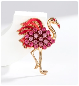 Détail de la broche flamant rose avec cristaux roses et émail rouge sur métal doré