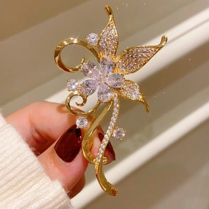 Detailed macro of vintage golden flower brooch with sparkling zircon rhinestones inlay