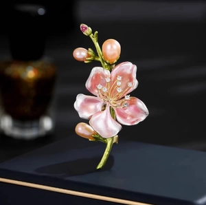Elegante spilla a fiore di magnolia con petali in smalto e perle su portagioie blu