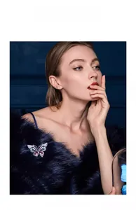 Detail view of aurora purple butterfly brooch on a model with elegant dark fur outfit