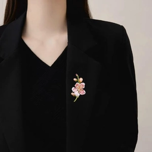 Elegante spilla a fiore di magnolia con petali rosa e perle su un blazer da abito nero