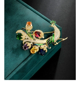 Détail de la broche paon de luxe avec pierres colorées et émail vert sur finition dorée