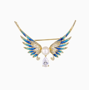 Broche ailes d'ange élégante avec perles et émail coloré sur une base dorée