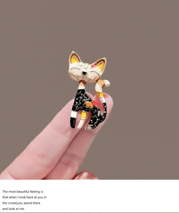 Detailed close-up of a Japanese style enamel cat brooch with red floral patterns
