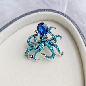 Blue crystal octopus brooch with silver base and light blue rhinestones in a heart box