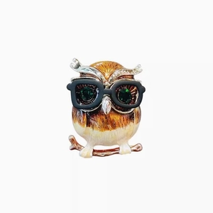 Broche hibou exquise avec yeux en gemmes vertes et lunettes noires sur fond blanc