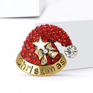 Broche bonnet de Noël mignonne avec strass rouges et base dorée sur un support blanc