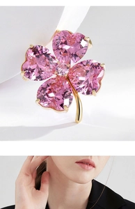 Détail de la broche trèfle rose avec cristaux en forme de cœur et tige dorée élégante