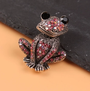 Vintage silver frog brooch pin paved with pink purple crystals on a black stone base