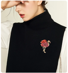 Broche flamant rose élégante avec strass roses épinglée sur un pull en maille noir