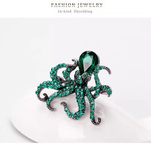 Vintage silver octopus brooch with vibrant green crystals and large pear-shaped stone